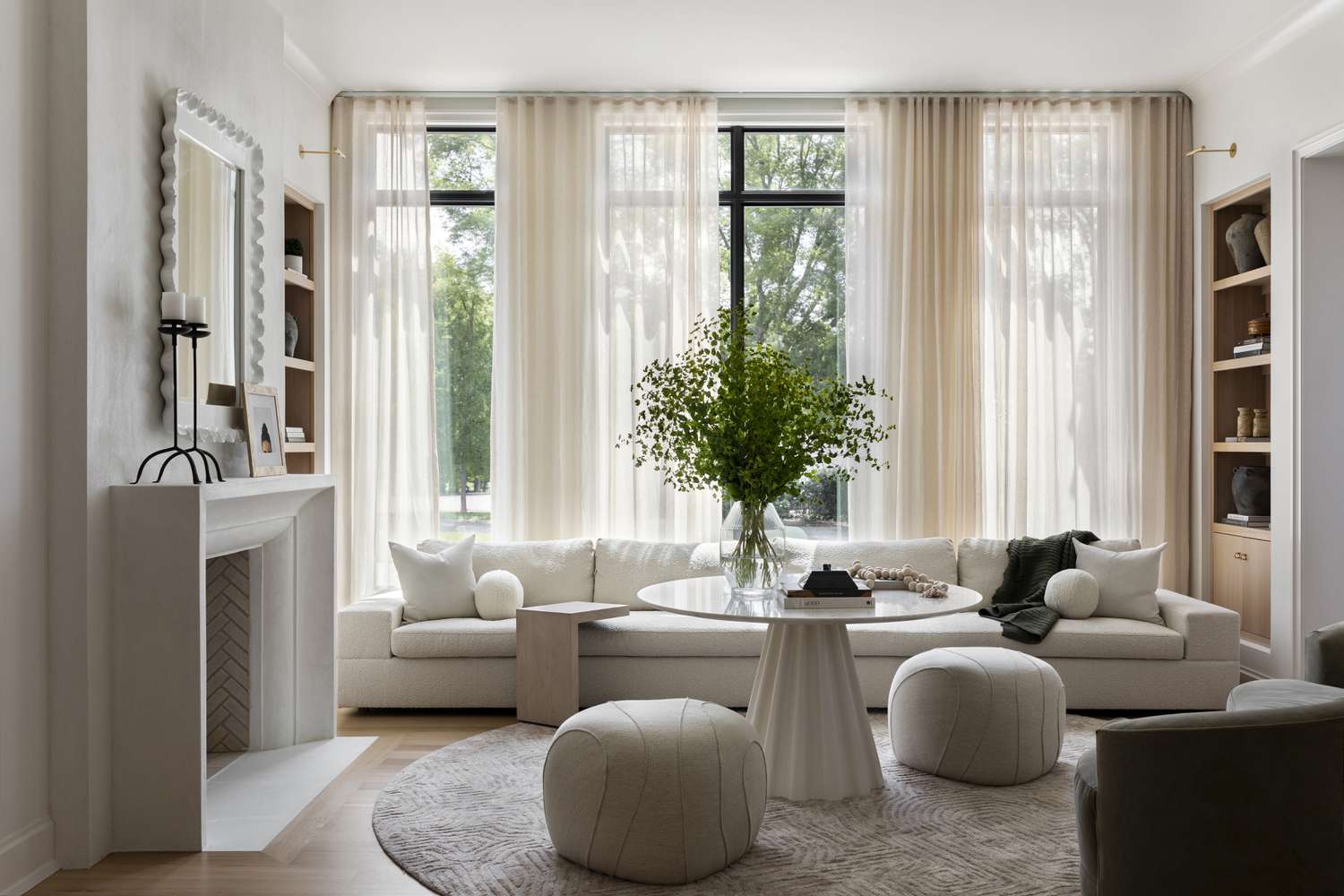 Calm neutral living room with curated white sofa, sheer curtains and greenery - Pure Living Lab's style philosophy of warm minimalism
